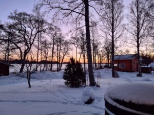 Aurinko laskee Anttooran lomakylässä talvella.